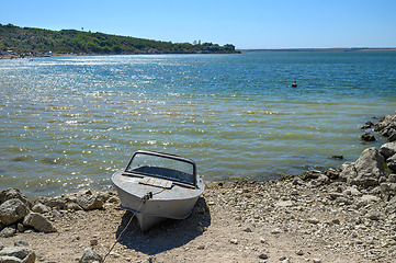 Image showing Empty old metal fishing motor boat at shore