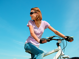 Image showing Young woman is sitting on her bicycle