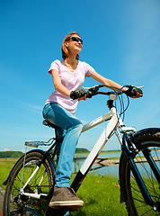 Image showing Young woman is sitting on her bicycle