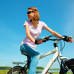 Image showing Young woman is sitting on her bicycle