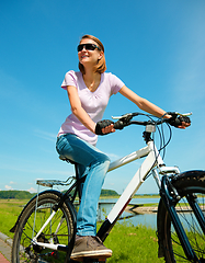 Image showing Young woman is sitting on her bicycle