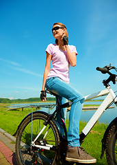 Image showing Young woman is sitting on her bicycle