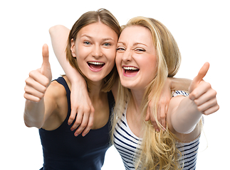 Image showing Two young happy women showing thumb up sign