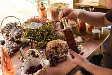 Image showing potion bottle in hand of herbalist