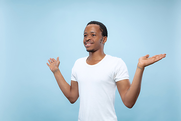 Image showing Half-length close up portrait of young man on blue background.