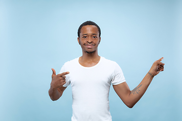 Image showing Half-length close up portrait of young man on blue background.