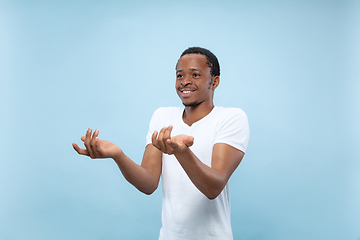 Image showing Half-length close up portrait of young man on blue background.