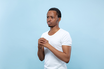 Image showing Half-length close up portrait of young man on blue background.