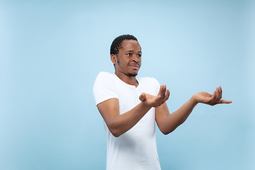 Image showing Half-length close up portrait of young man on blue background.