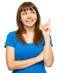 Image showing Portrait of a young woman pointing to the right