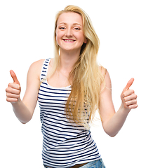 Image showing Young woman is showing thumb up gesture