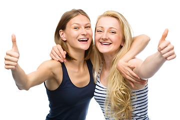 Image showing Two young happy women showing thumb up sign