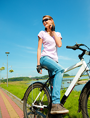 Image showing Young woman is sitting on her bicycle