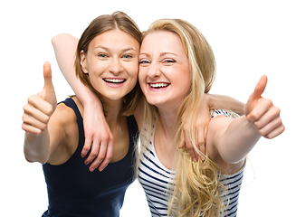 Image showing Two young happy women showing thumb up sign