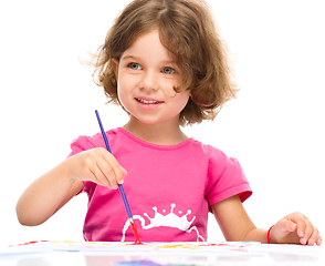 Image showing Little girl is painting with gouache