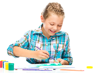 Image showing Little girl is drawing using pencils