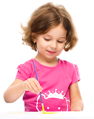 Image showing Little girl is painting with gouache