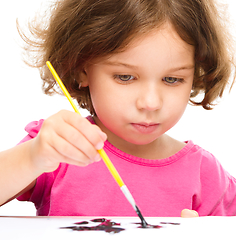 Image showing Little girl is painting with gouache