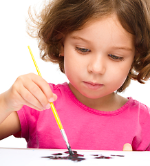 Image showing Little girl is painting with gouache