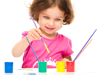 Image showing Little girl is painting with gouache