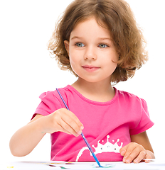 Image showing Little girl is painting with gouache