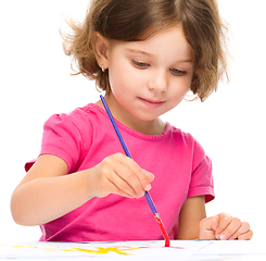 Image showing Little girl is painting with gouache