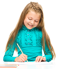 Image showing Little girl is drawing using pencils