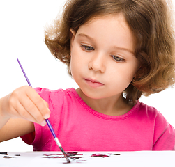 Image showing Little girl is painting with gouache