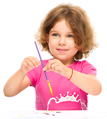 Image showing Little girl is painting with gouache