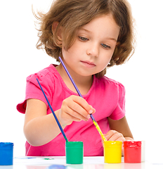 Image showing Little girl is painting with gouache