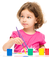 Image showing Little girl is painting with gouache