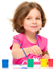 Image showing Little girl is painting with gouache