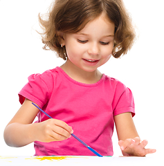 Image showing Little girl is painting with gouache