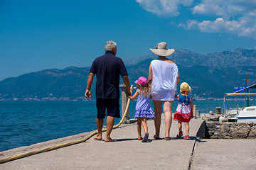Image showing grandparents and granddaughters walking by the sea