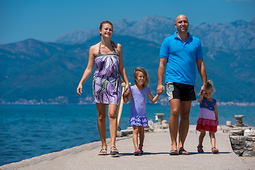 Image showing young happy family walking by the sea