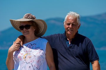 Image showing senior couple hugging while walking  by the sea