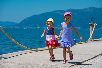 Image showing little sisters running on the beach coast