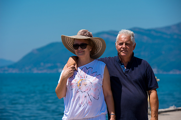 Image showing senior couple hugging while walking  by the sea