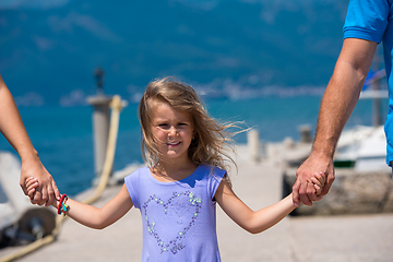 Image showing young happy family walking by the sea