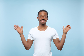 Image showing Half-length close up portrait of young man on blue background.