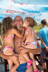 Image showing portrait of young happy father with daughters by the sea