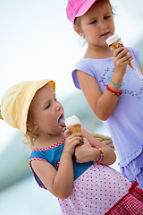Image showing little girls eating ice cream by the sea
