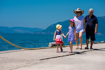 Image showing grandparents and granddaughters walking by the sea