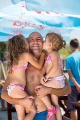 Image showing portrait of young happy father with daughters by the sea