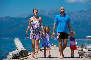 Image showing young happy family walking by the sea