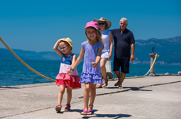 Image showing grandparents and granddaughters walking by the sea