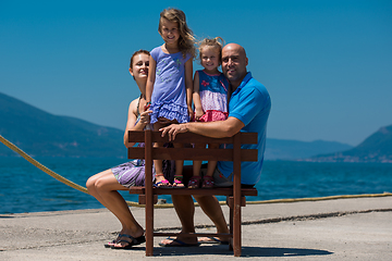 Image showing portrait of young happy family with daughters by the sea