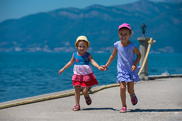 Image showing little sisters running on the beach coast