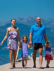 Image showing young happy family walking by the sea