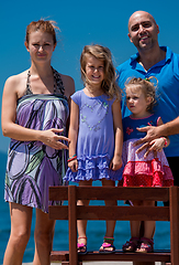 Image showing portrait of young happy family with daughters by the sea